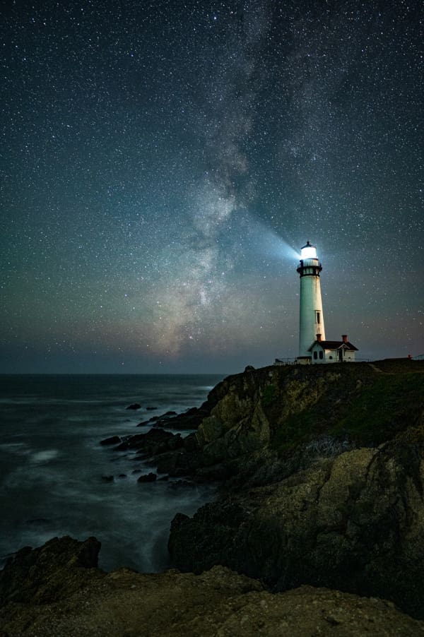 A lighthouse on a cliff by the ocean