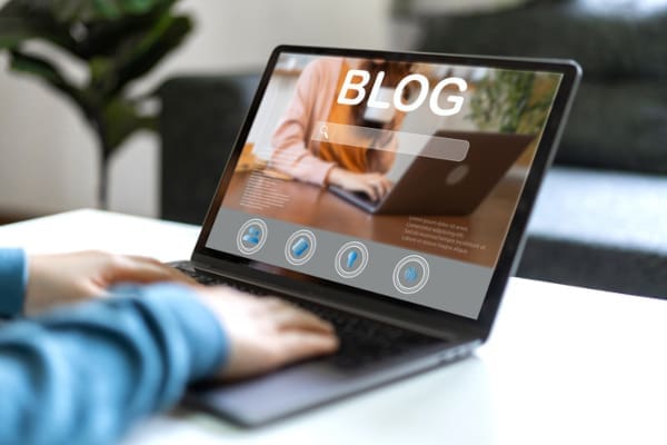 A person on a laptop reading a company's blog