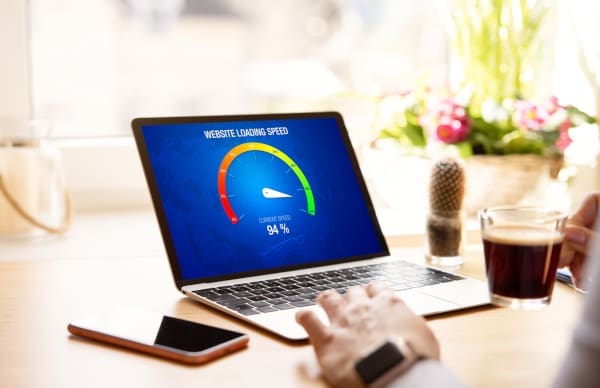 A laptop with a graphical dial on the screen showing good page speed